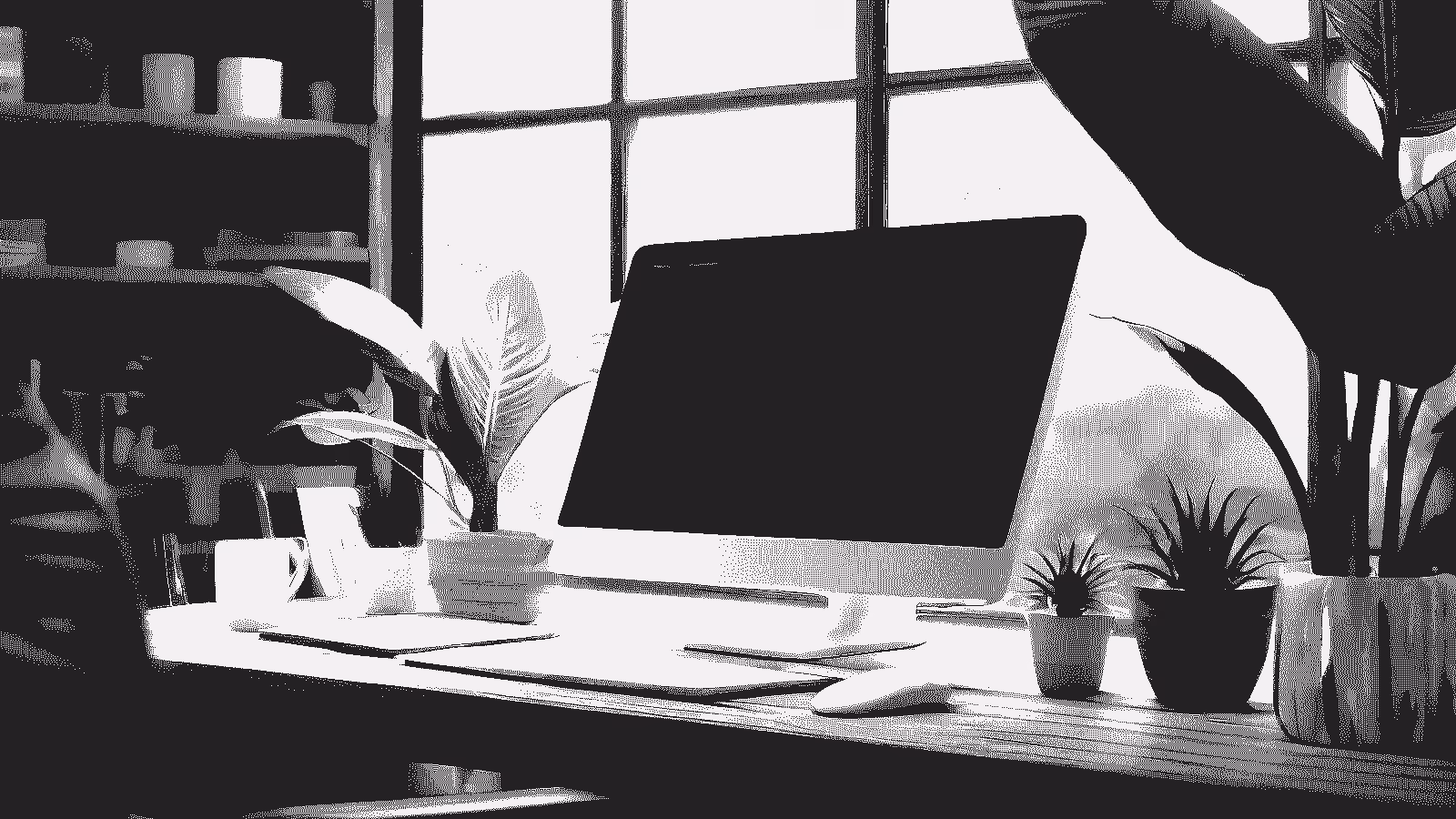Bureau et écran d’ordinateur entouré de plantes